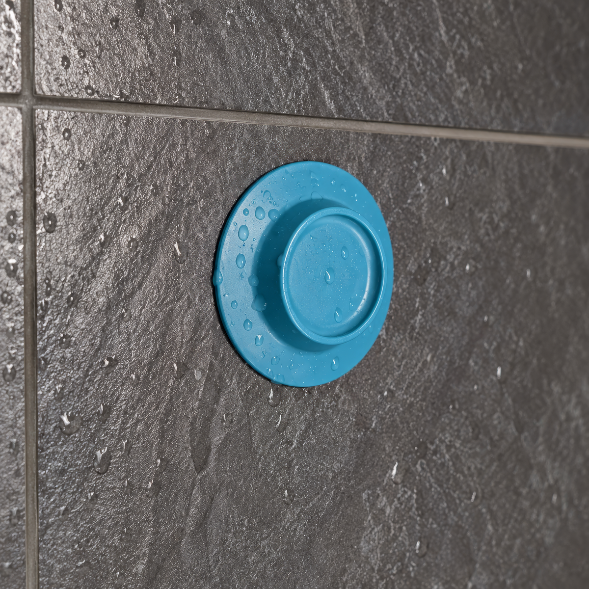Hanno's Grip – magnetischer Seifenhalter in Blau an nasser, dunkelgrauer Duschfliese montiert